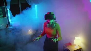 Young woman using virtual reality goggles in the dark room with neon lighting 4K slow motion RED camera. Wireless technologies. video