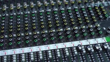 An audio mixer with multiple sliders and knobs being adjusted video