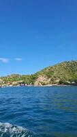 The view from a boat on the ocean with a hill in the background video