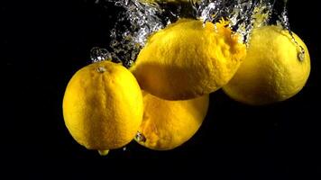Super slow motion of falling lemon into splashing water. Lemonade cooking concept. Filmed on high speed cinema camera, 4k 1000 fps. video
