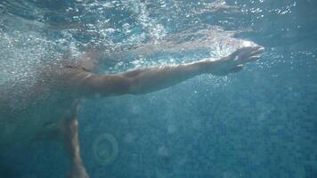Underwater view of professional swimmer training in swimming pool, 4k 120 fps super slow motion raw . Triathlete swim in black wetsuit video