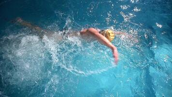 Underwater view of professional swimmer training in swimming pool, 4k 120 fps super slow motion raw . Triathlete swim in black wetsuit video