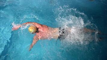 Underwater view of professional swimmer training in swimming pool, 4k 120 fps super slow motion raw . Triathlete swim in black wetsuit video