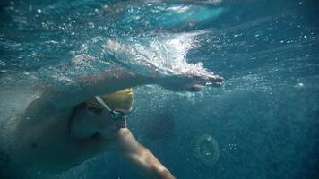 Underwater view of professional swimmer training in swimming pool, 4k 120 fps super slow motion raw . Triathlete swim in black wetsuit video