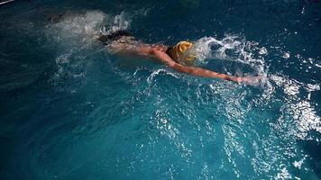 Underwater view of professional swimmer training in swimming pool, 4k 120 fps super slow motion raw . Triathlete swim in black wetsuit video