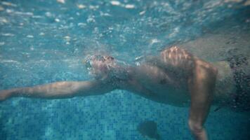 Underwater view of professional swimmer training in swimming pool, 4k 120 fps super slow motion raw . Triathlete swim in black wetsuit video