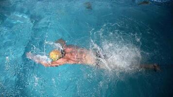 Underwater view of professional swimmer training in swimming pool, 4k 120 fps super slow motion raw . Triathlete swim in black wetsuit video