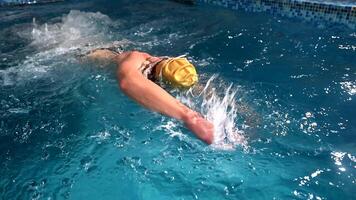 Underwater view of professional swimmer training in swimming pool, 4k 120 fps super slow motion raw . Triathlete swim in black wetsuit video