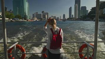 A woman on boat deck enjoying city skyline view across the water video