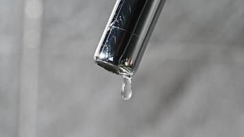 Drop of water drips from the tap. Beautiful fresh and clean water flowing from a tap. Close-up front view broken chrome faucet in kitchen. Everyday problems, wasting water and energy video