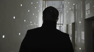 Back view of businessman walking in modern office building. Stock. The businessman stay in the business center photo