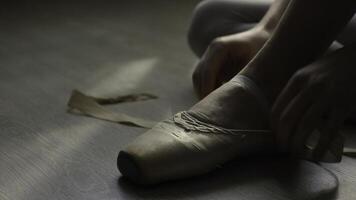 ballet dancer tie up her pointes. Ballet dancer tying ballet shoes before training photo