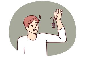 Man with bug in hand, looks at insect and gets scared suffering from arachnophobia and disgust vector