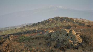 Vast landscape with distant snow capped mountains in early morning light video