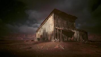 Abandoned wooden barn under cloudy skies in a desolate landscape video