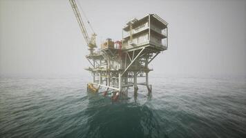 Old oil platform standing in open water with foggy atmosphere at dawn video