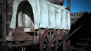 Old wooden wagon covered with cloth near an ancient wooden structure video