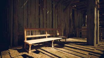 A rustic wooden bench placed in an old barn during the late afternoon sun video