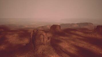 Vast desert landscape at dusk with eerie shadows and red rock formations video