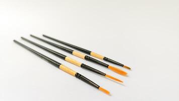 Different brushes with paints on white background photo