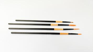 Different brushes with paints on white background photo