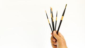Different brushes with paints on white background photo