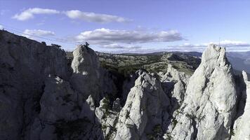 Aerial panoramic view of mountain cableway, above green trees on blue, cloudy sky background. Shot. Fascinating cliffs covered with coniferous forest in a summer sunny day. photo