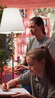 Therapist guiding a troubled teen through creative therapy system, using drawing as a method to manage intrusive thoughts and mental health. The mother observes, offering emotional support. Camera B. video