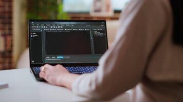 Asian female programmer works on coding software in a home office setup, typing code on a laptop. IT expert uses digital tools for multitasking, software development and app development. Camera B. video