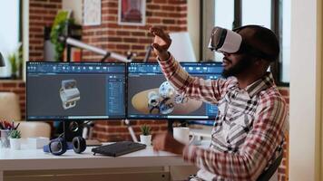African american software developer working with virtual reality headset and artificial intelligence to create new industrial prototypes and manufacturing tools on CAD software. Camera B. video