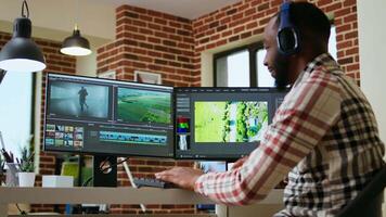 African american filmmaker editing a shoot in post production, using a modern tech setup for creative project. Living room workspace with editing software and dual monitors. Camera A. video