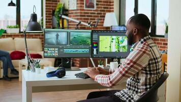 Male creator edits a multimedia project at a modern office, using professional tech tools and editing software to manage timeline editing and production. Work from home. Camera A. video
