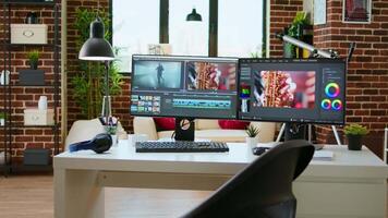 Empty office desk with a editing software running on computer, production and mixing to edit footage. Professional program for filmmaking media, creative studio. video