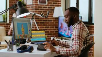 Freelance creative graphic editor works remotely editing digital images in his home office setup. Working with professional software tools and techniques on artistic design. Camera B. video