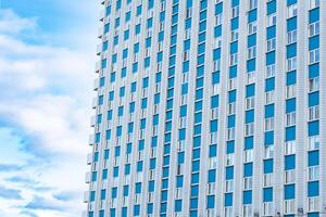 Modern building facade against cloudy sky. Urban architecture and design concepts. photo