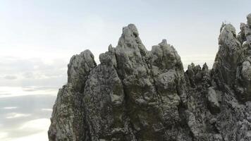 Close up for sharp rock formation on blue, cloudy sky background. Shot. Aerial for sharp peaks of mountain and a skyline on background. photo