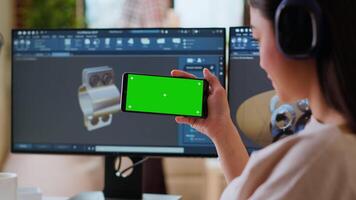 Software developer works in a modern office with green screen and dual monitors. Home workspace emphasizes industrial innovation and expertise in manufacturing design. Camera B. video