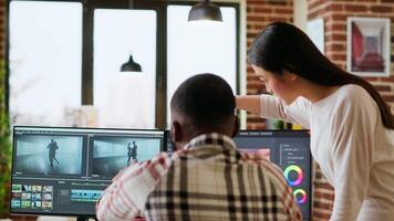 Diverse mixed race couple working as a team for a freelance shoot, editing and mixing clips in post production using modern software. Multiethnic people do remote work. Camera B. video