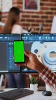 Vertical African american industrial designer works on 3D renders and isolated mockup, using digital tools and dual monitors. Engineer driven by creativity and technical expertise in design. Camera B. video