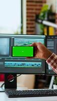 Vertical Male filmmaker editing a project in a modern color grading software, using copy space screen. Young man employee works on dual monitors during creative process of production. Camera B. video