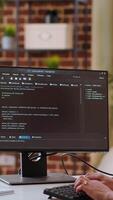 Vertical Asian woman is seen typing code for an app development project on her computer, working from a home office. IT specialist engineer focuses on software programming and remote tech work. Camera B. video