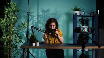 Content creator doing relaxing ASMR type of for fans, recording with professional camera. Online show host using advanced microphone and filming gear to create relaxing , camera B video