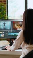 Vertical Female editor focuses on color grading while working on a film project in a professional creative studio. Professional woman uses advanced tech tools for editing. Camera B. video