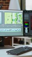 Vertical Empty modern office workspace with dual monitors displaying a editing timeline and color grading tools. Perfect for filmmakers and media creators working remotely on projects. video