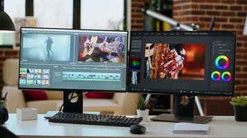 Empty desk in living room featuring dual monitors displaying a project, production. Office setup optimized for remote work with editing software and tech tools for media creation. video