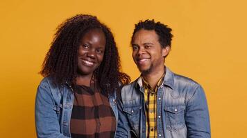 African american romantic couple smiling and posing next to each other, being in love and showing affection in front of the camera. Happy husband and wife embracing with passion. Camera A. video