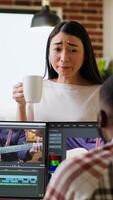 Vertical Creative team interracial partners collaborating on a editing project, using high end production software for color grading and mixing. Diverse couple uniting forces for work. Camera B. video