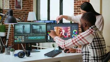 Diverse mixed race couple working as a team for a freelance shoot, editing and mixing clips in post production using modern software. Multiethnic people do remote work. Camera A. video