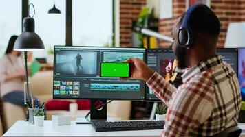 Male filmmaker editing a project in a modern color grading software, using copy space screen. Young man employee works on dual monitors during creative process of production. Camera B. video