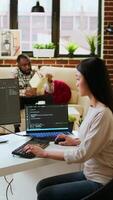 Vertical Asian female developer coding cloud computing applications on pc in a modern tech workspace. Woman IT specialist focuses on the software development process for productivity and innovation. Camera A. video
